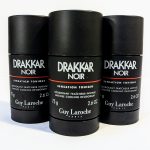 Three black cylindrical deodorant sticks labeled "Drakkar Noir" by Guy Laroche, each with a net weight of 2.6 oz (75 g). They are arranged side by side on a white surface.