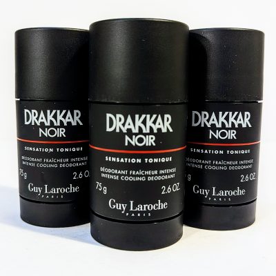 Three black cylindrical deodorant sticks labeled “Drakkar Noir” by Guy Laroche, each with a net weight of 2.6 oz (75 g). They are arranged side by side on a white surface.