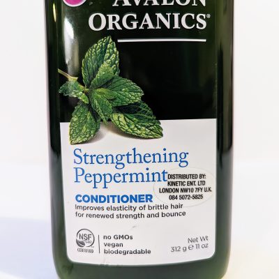 A bottle of "Avalon Organics Strengthening Peppermint Conditioner," promoting elasticity and strength for brittle hair. The label notes it is vegan, GMO-free, and biodegradable. Net Weight: 11 oz (312g).