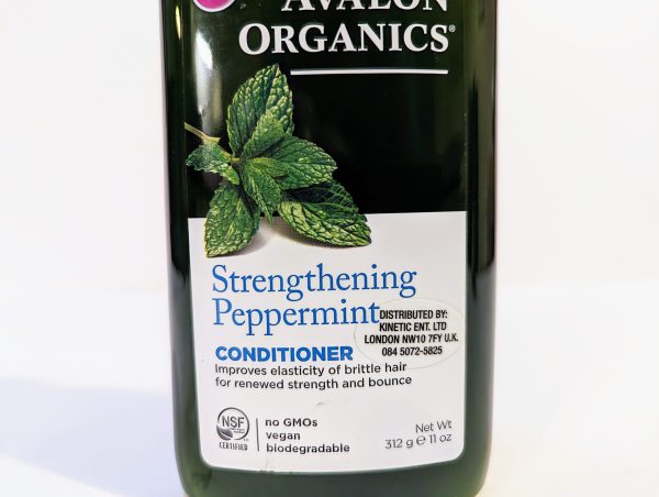 A bottle of "Avalon Organics Strengthening Peppermint Conditioner," promoting elasticity and strength for brittle hair. The label notes it is vegan, GMO-free, and biodegradable. Net Weight: 11 oz (312g).