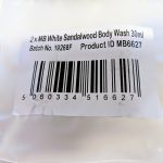 Close-up of a product label showing a barcode and details for "2 x MB White Sandalwood Body Wash 30ml," batch number 19268F, and product ID MB6627.