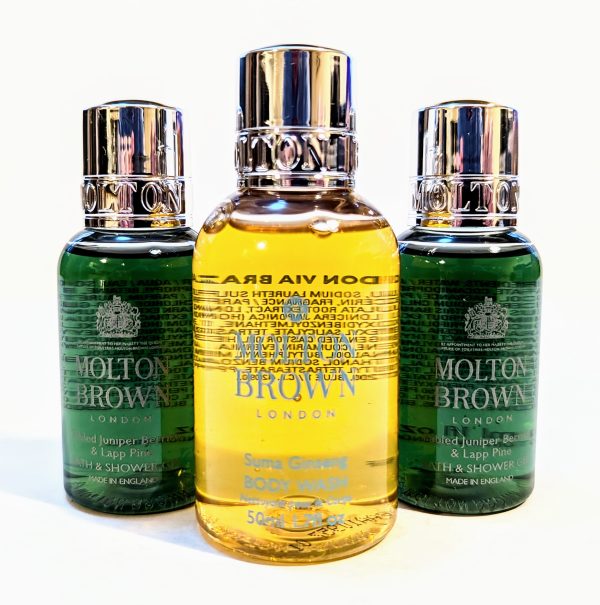 Three bottles of Molton Brown bath products, including two green bottles labeled Bath & Shower Gel and one yellow bottle labeled Body Wash, are arranged on a white background.