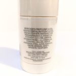 Close-up of a cylindrical container showing the ingredient list of a cosmetic product. The text includes various chemical components and mentions that it is made in Monaco.