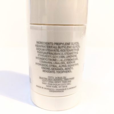 Close-up of a cylindrical container showing the ingredient list of a cosmetic product. The text includes various chemical components and mentions that it is made in Monaco.