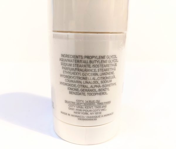 Close-up of a cylindrical container showing the ingredient list of a cosmetic product. The text includes various chemical components and mentions that it is made in Monaco.