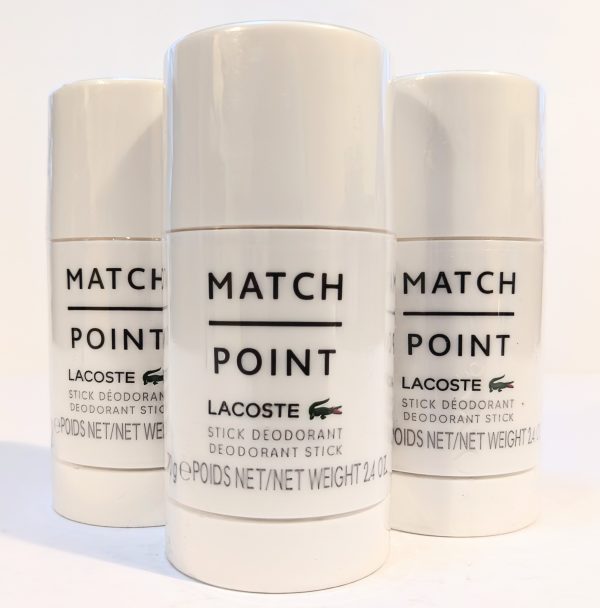 Three Lacoste Match Point stick deodorants are displayed upright, with the product name and logo visible on the front of each white container.