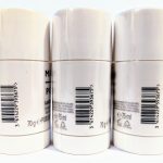 Three white cylindrical containers of a grooming product are aligned next to each other, showing different barcodes and labels. Each container holds 75 ml and has a 70 g net weight.