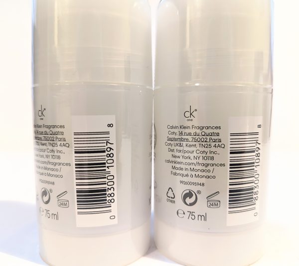 Two white bottles of Calvin Klein fragrance, each with a barcode and product description printed on the back label. Each bottle has a capacity of 75 ml.