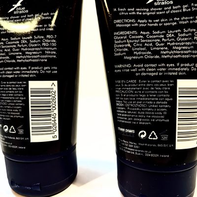 Two black bottles of shower gel with ingredient lists, barcodes, and usage instructions displayed on the back view. One bottle's text reads 'blue stratos', and both have white labels.