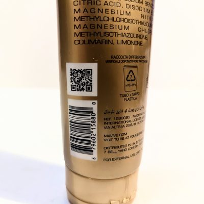 A close-up of a product tube displaying various ingredient names, a QR code, a barcode, recycling symbols, and multilingual text including an external use warning.