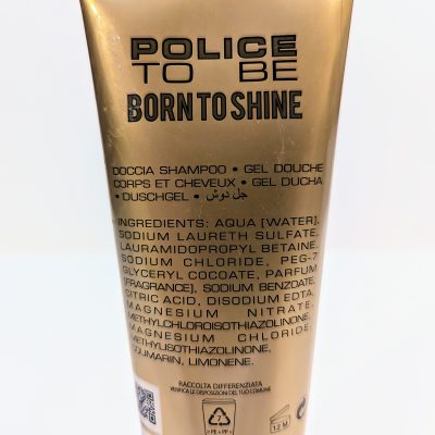 A gold tube of Police to Be Born to Shine shower gel. The back label lists ingredients including aqua, sodium laureth sulfate, and parfum, among others, in multiple languages.