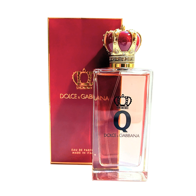 A rectangular bottle of Dolce & Gabbana perfume with a crown-shaped cap, placed in front of its matching red and gold box. The bottle and box feature the Dolce & Gabbana logo.