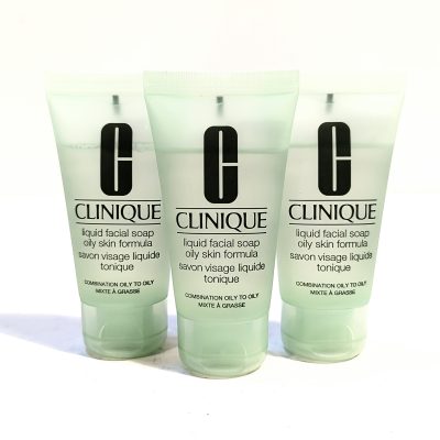 Three tubes of Clinique liquid facial soap for oily skin are arranged in a row. The packaging is light green, and each tube is labeled with the product name and usage instructions in English and French.