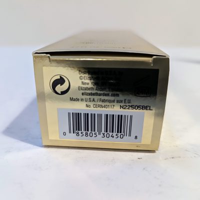The bottom side of a rectangular gold box showing a barcode, recycling symbol, and text indicating the product is made in the USA by Elizabeth Arden.