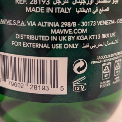 Close-up of a product label showing distribution, usage instructions, and recycling symbols. Includes a barcode and a 12-month expiration icon. Text indicates the product is made in Italy and distributed in the UK.