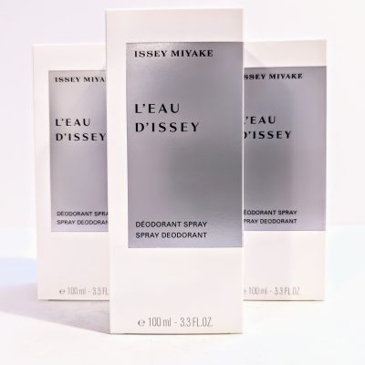 Three boxed Issey Miyake L'Eau d'Issey deodorant sprays, each with a silver label, arranged in a triangular formation on a white surface.