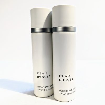 Two white cylindrical cans of L’Eau d’Issey spray deodorant are positioned side by side against a plain background.