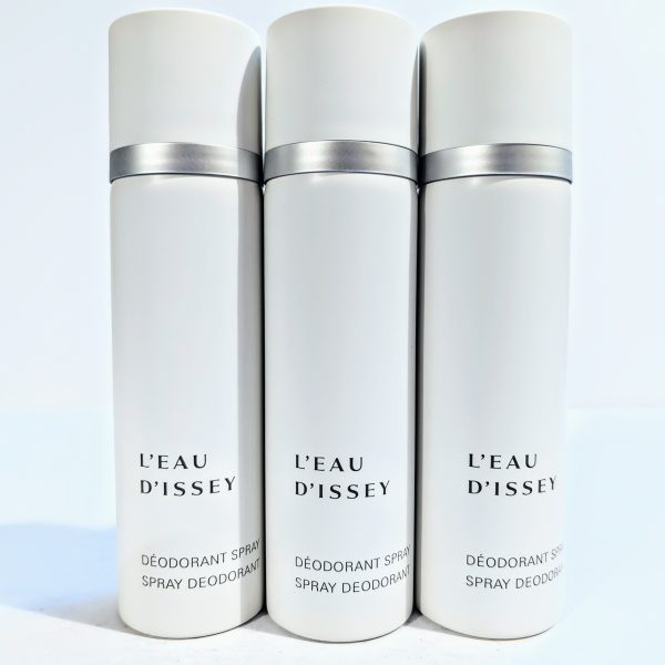 Three white cans of L'Eau D'Issey spray deodorant with gray caps are standing side by side against a plain background.