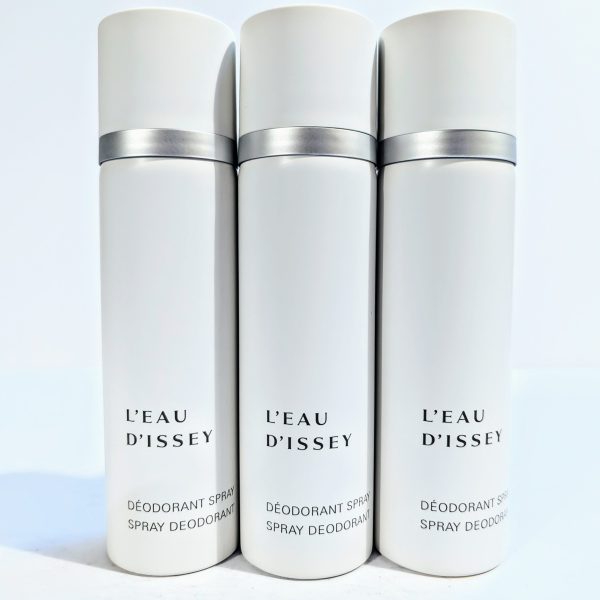 Three white cans of L'Eau D'Issey spray deodorant with gray caps are standing side by side against a plain background.