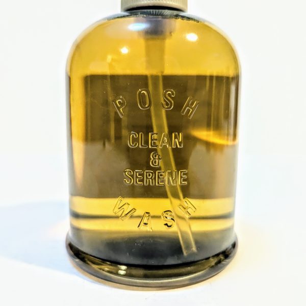 A clear brown bottle with the label "Posh Clean & Serene Wash" displayed on the front.