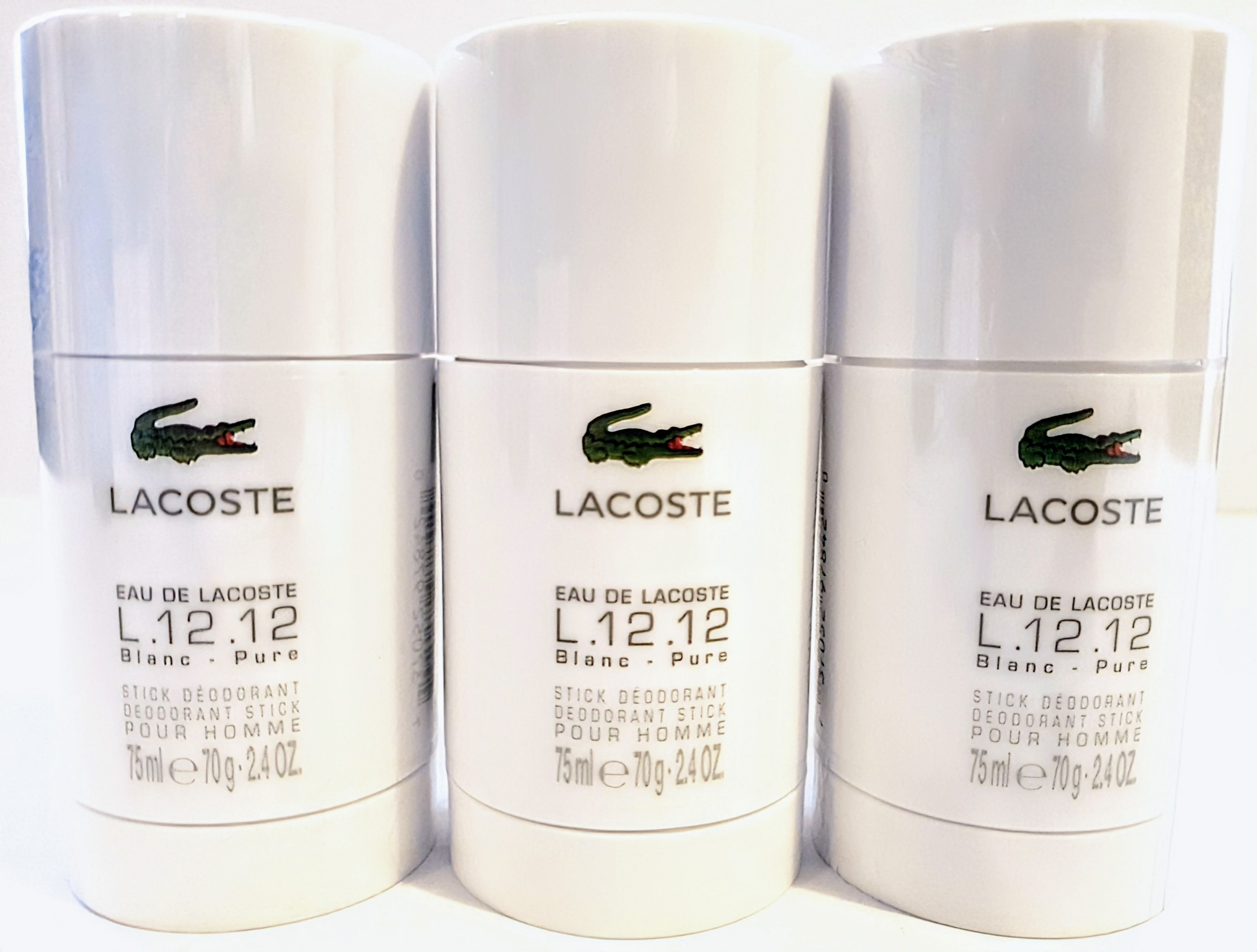 Three Lacoste L.12.12 Blanc Pure stick deodorants for men, each 75ml, displayed side by side.