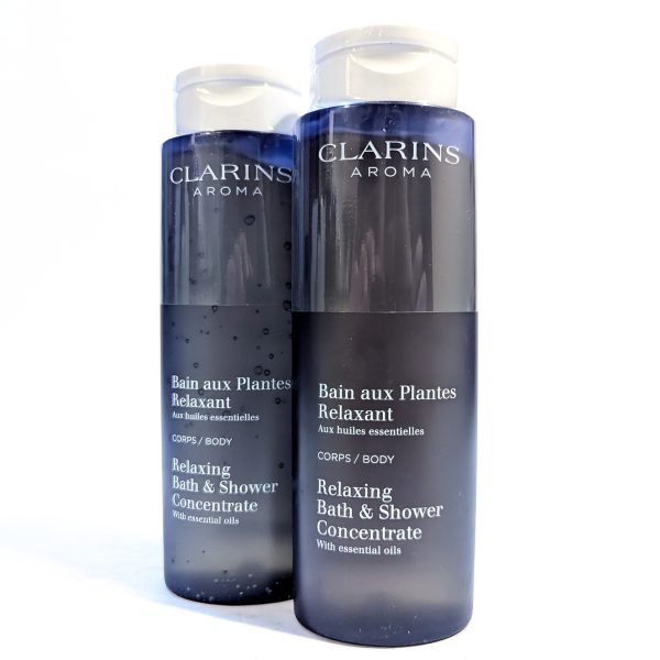 Two bottles of Clarins Aroma Relaxing Bath & Shower Concentrate, each with 200ml capacity, are displayed against a white background. Two bottles of Clarins Aroma Relaxing Bath & Shower Concentrate, each with 200ml capacity, are displayed against a white background.
