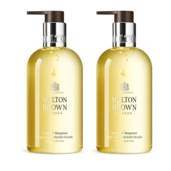 Two bottles of Molton Brown Orange & Bergamot Hand Wash 300ml with pump dispensers, each containing yellow liquid.