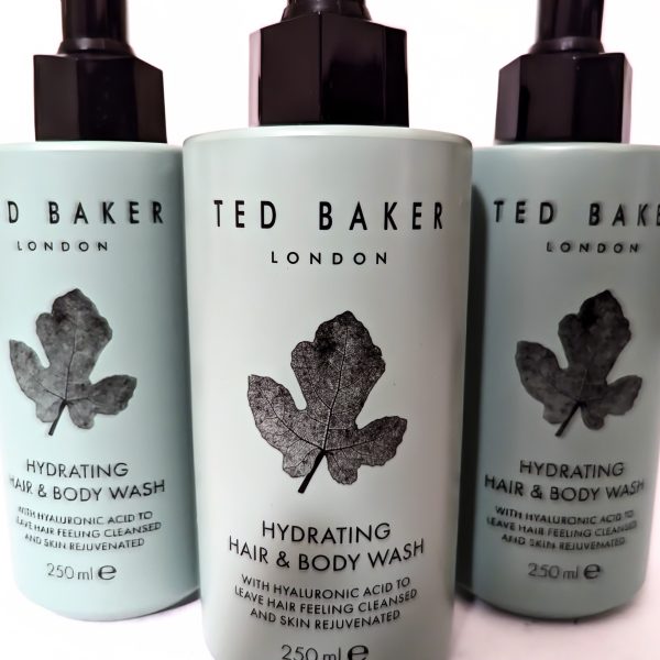 Three bottles of Ted Baker London Hydrating Hair & Body Wash with hyaluronic acid, 250ml each, featuring a black leaf design on a light blue background.