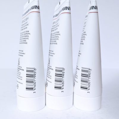 Three white cylindrical tubes with printed text and barcodes on a white background.