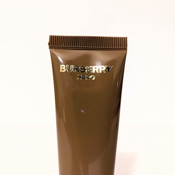 A close-up of a brown tube labeled "Burberry Hero" against a plain white background.