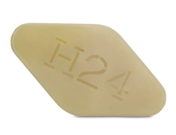 A trapezoidal beige pill imprinted with "H24" refers to the Hermès H24 Face, Body And Hair Cleansing Bar, a 100g soap for men.