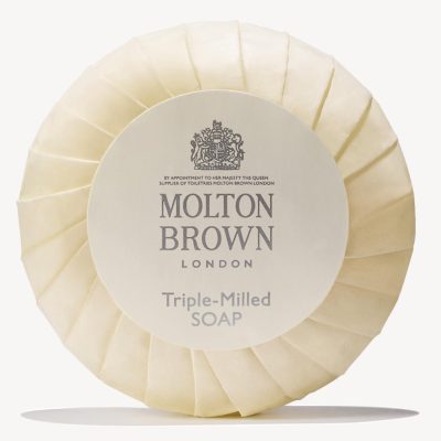 Round Molton Brown triple-milled milk soap wrapped in cream paper featuring a logo and text, available as 5x 25g miniatures.