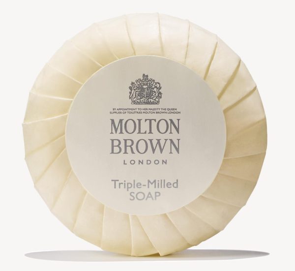 Round Molton Brown triple-milled milk soap wrapped in cream paper featuring a logo and text, available as 5x 25g miniatures.