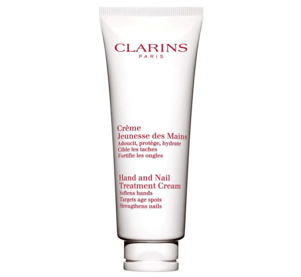 A white tube of Clarins Skincare Hand & Nail Treatment Cream 100ml, featuring red text and designed to soften hands and strengthen nails.