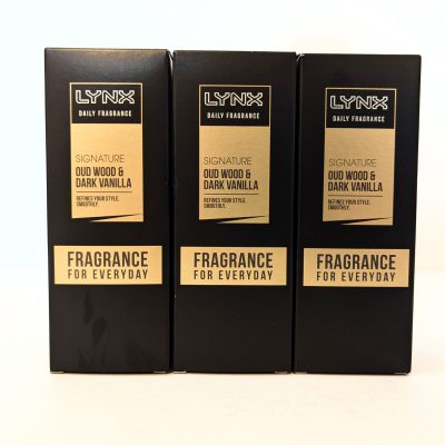 Three black boxes of Lynx Daily Fragrance, Signature Oud Wood & Dark Vanilla scent, are displayed side by side with "Fragrance for Everyday" written on the front.