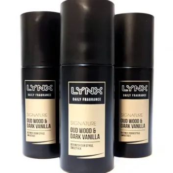 Three cans of Lynx Daily Fragrance Signature Oud Wood & Dark Vanilla are standing upright, with the center can slightly in front of the other two.
