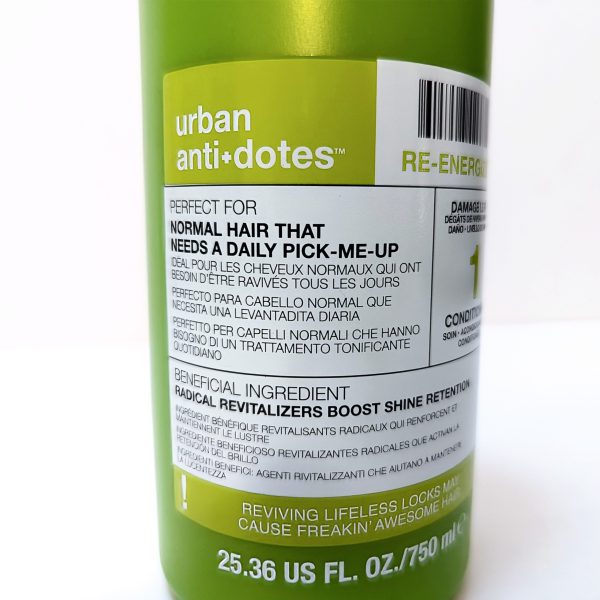 Close-up of a green shampoo bottle labeled "urban anti+dotes," detailing benefits for normal hair and listing ingredients and instructions in English, French, and Spanish.