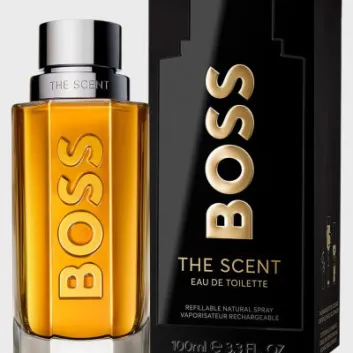 A bottle of Hugo Boss The Scent EDT for Men, 100ml, is displayed beside its black and gold packaging, highlighting it as a refillable spray.