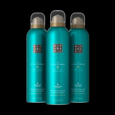 Three 200ml bottles of Rituals The Ritual of Karma Foaming Shower Gel, each with a gold cap, are shown against a black background.