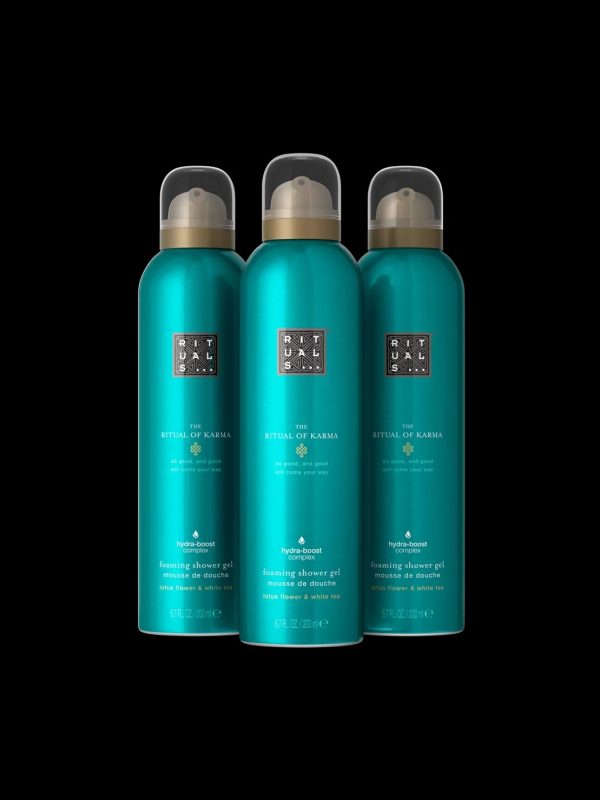 Three 200ml bottles of Rituals The Ritual of Karma Foaming Shower Gel, each with a gold cap, are shown against a black background.
