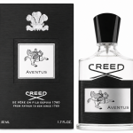 A Creed Aventus Eau de Parfum EDP 50ml Spray for Men bottle and its black box are displayed side by side, each adorned with a silver label featuring a horse and rider illustration.
