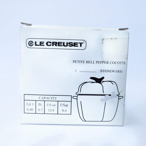White box packaging for a Le Creuset petite bell pepper cocotte, with product illustration and capacity details listed in liters, pints, ounces, and quarts.