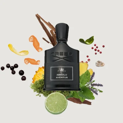 A black bottle of Creed Absolu Aventus perfume surrounded by various fruits, herbs, and spices on a white background.