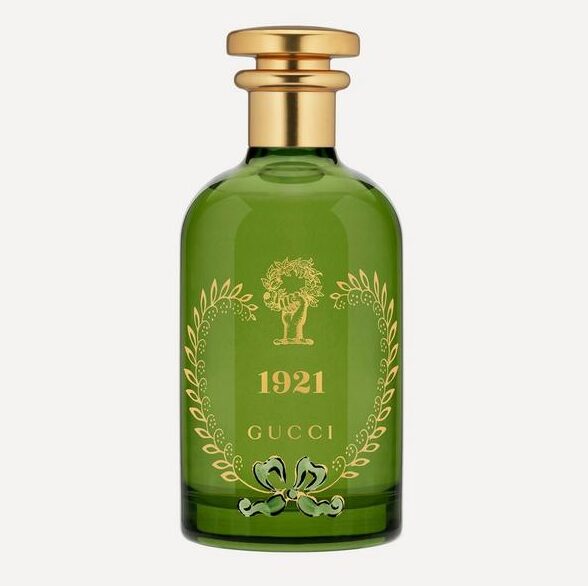 The Gucci 1921 Eau de Parfum Spray, Unisex, 100ml, comes in a green glass bottle with a gold cap, gold accents, and a tree motif on the front.