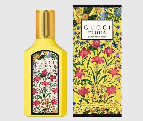 A yellow bottle of Gucci Flora Gorgeous Orchid EDP 50ml Spray for women is displayed beside its matching floral-patterned box. A yellow bottle of Gucci Flora Gorgeous Orchid EDP 50ml Spray for women is displayed beside its matching floral-patterned box.