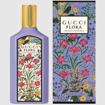 A bottle and box of Gucci Flora Gorgeous Magnolia Eau de Parfum for Women, 100ml Spray, both in purple with a floral design featuring pink, yellow, and blue flowers.