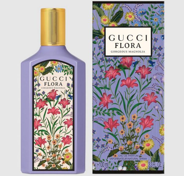 A bottle and box of Gucci Flora Gorgeous Magnolia Eau de Parfum for Women, 100ml Spray, both in purple with a floral design featuring pink, yellow, and blue flowers. A bottle and box of Gucci Flora Gorgeous Magnolia Eau de Parfum for Women, 100ml Spray, both in purple with a floral design featuring pink, yellow, and blue flowers.