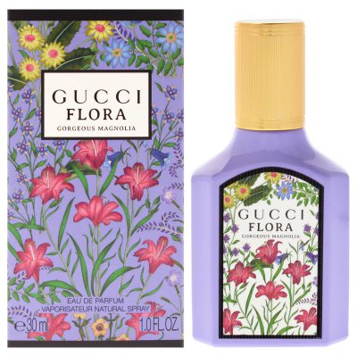 A bottle and box of Gucci Flora Gorgeous Magnolia Eau de Parfum for Women, 100ml Spray, featuring floral designs and purple packaging.