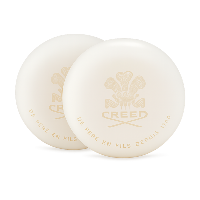 Two round, white 150g Creed Aventus Millesime Bars of Soap for Men, each featuring the Creed logo and gold French text "De Père en Fils Depuis 1760.