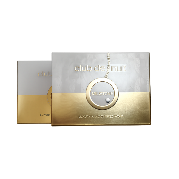 Two rectangular perfume boxes labeled "club de nuit Milstone," with a metallic gold and silver design, partially overlapping each other on a white background. Two rectangular perfume boxes labeled "club de nuit Milstone," with a metallic gold and silver design, partially overlapping each other on a white background.